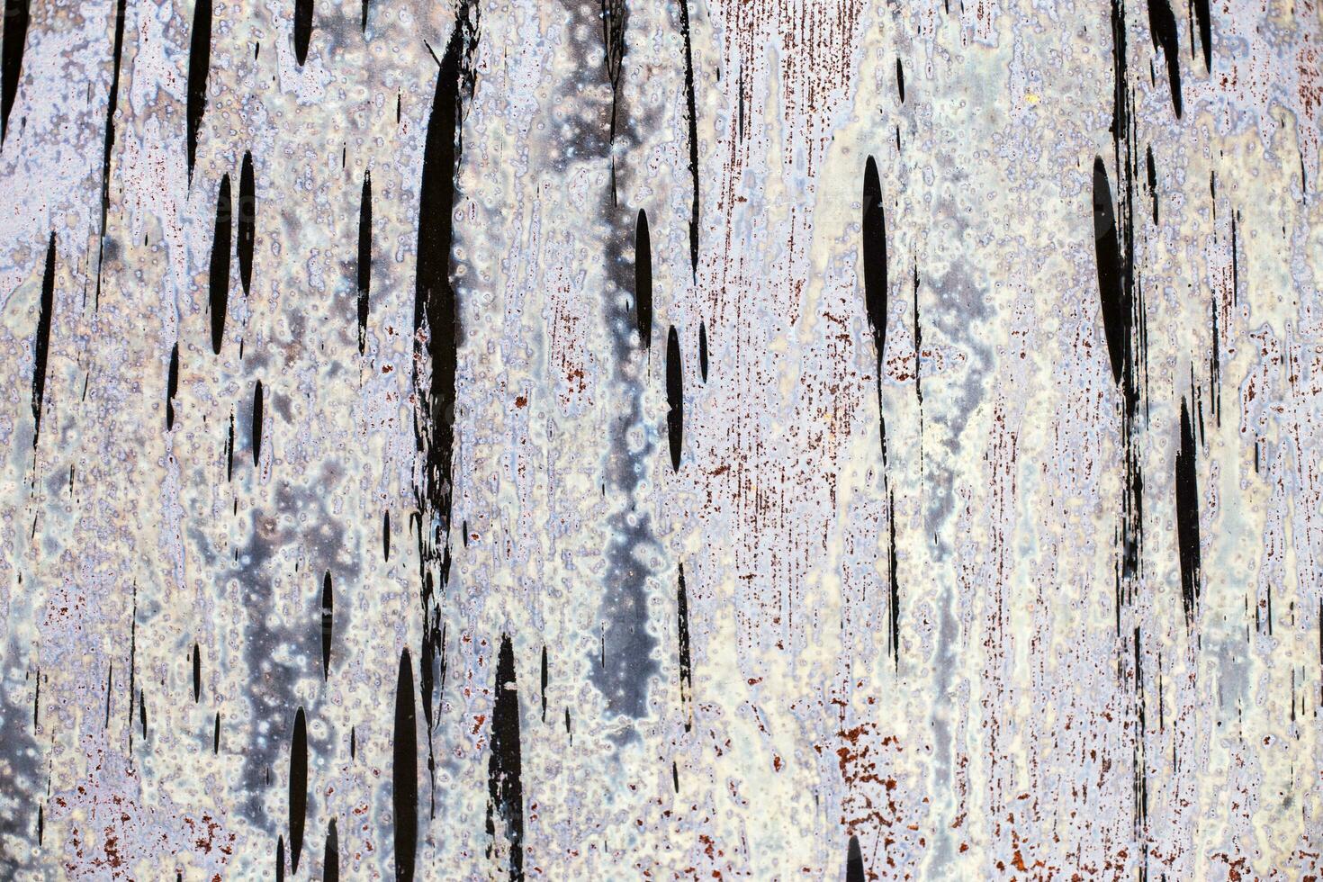 Old gray sheet metal smeared with black tar. shabby rusty metal surface. photo