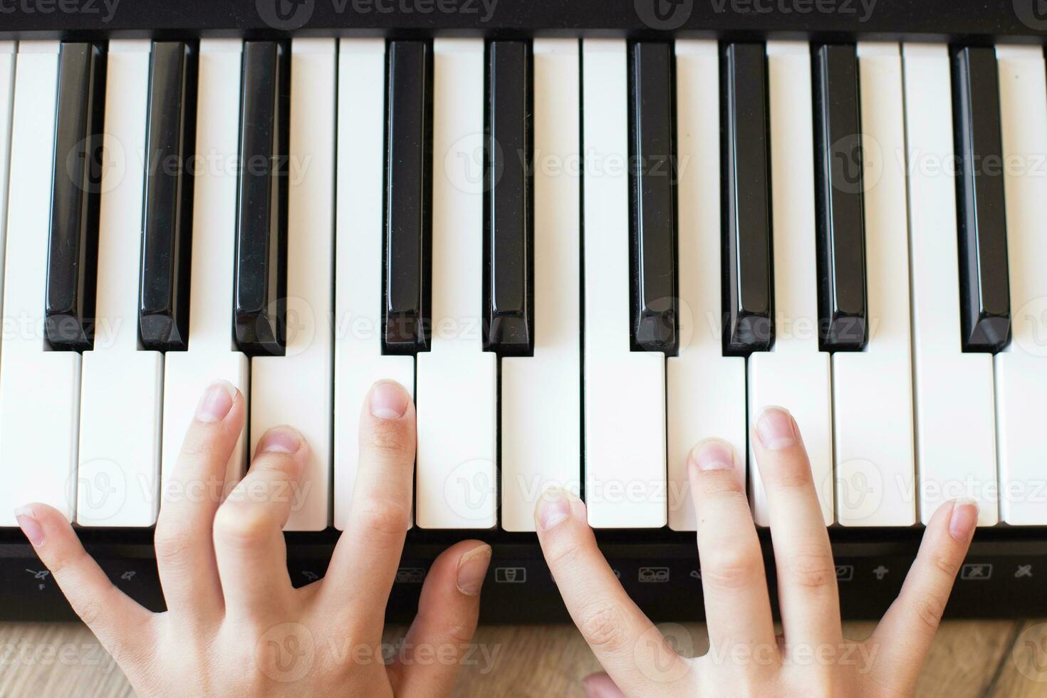 Child hands is playing, learning and practicing the piano. Piano chords In the key. photo