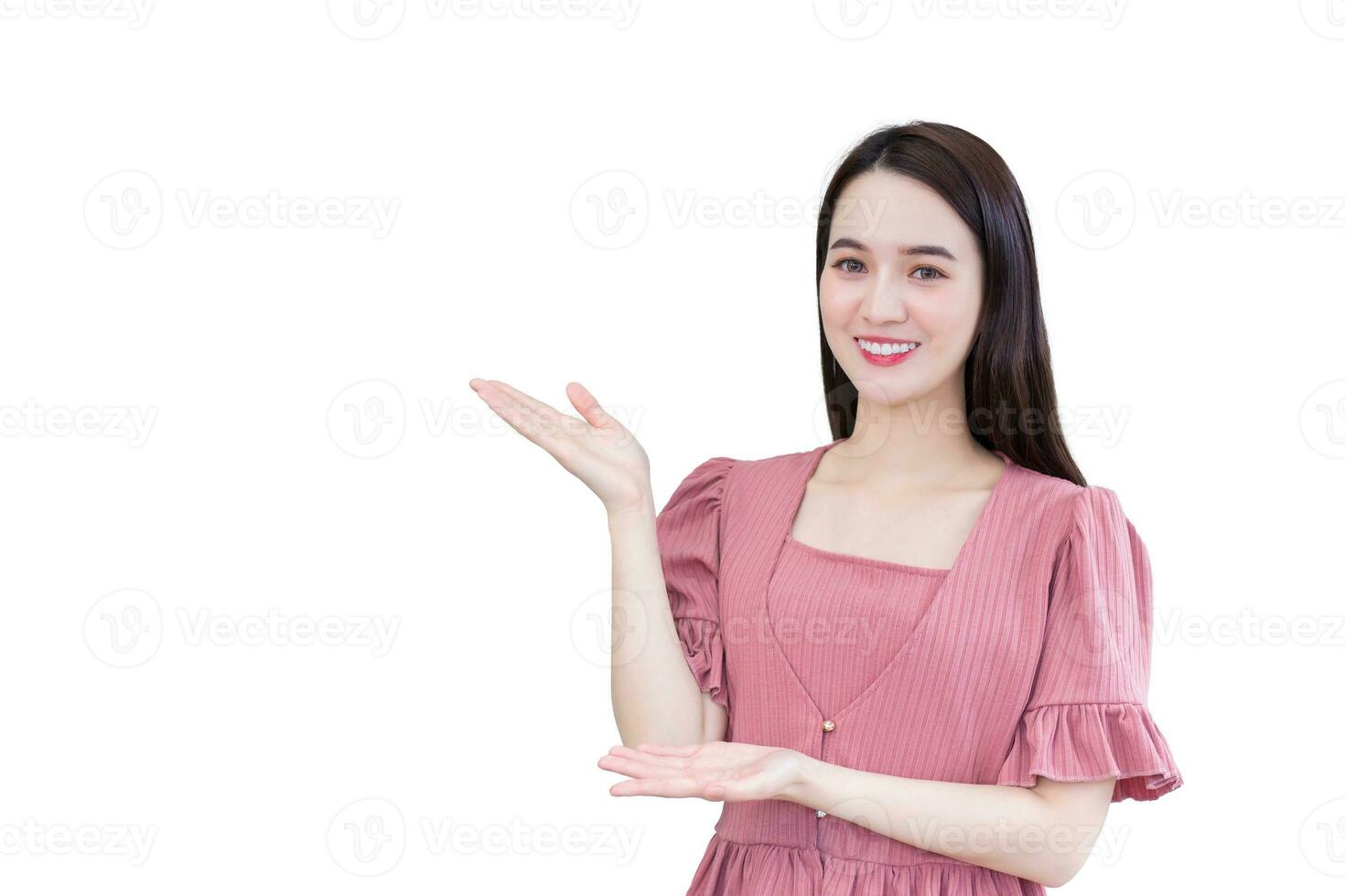 Professional young Asian business woman office worker who wears pink dress is standing and smiling shows hand to present something while isolated on white background. photo
