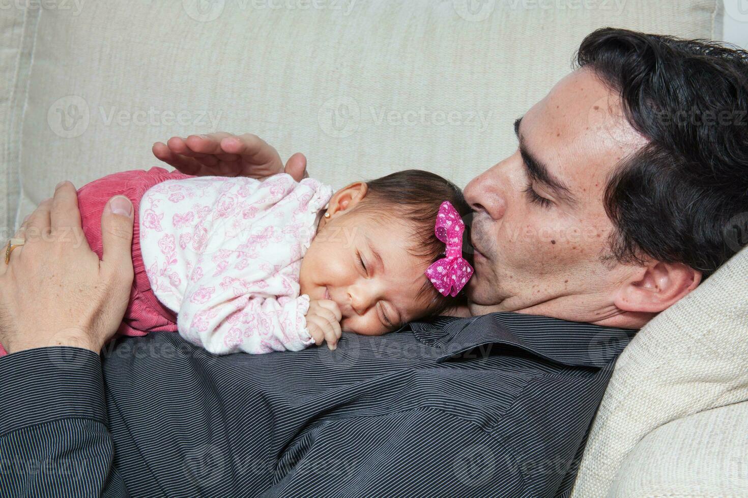 Portrait of young father at home with his one month baby girl. Fatherhood concept. Family love concept. photo