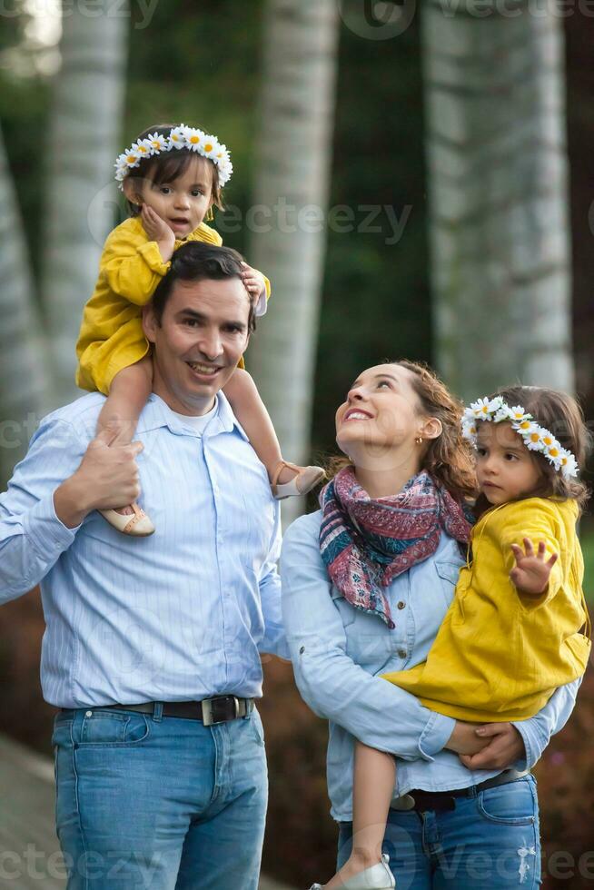 Family of four having fun outdoors in a beautiful sunny day at the park. Happiness concept. Family concept. photo