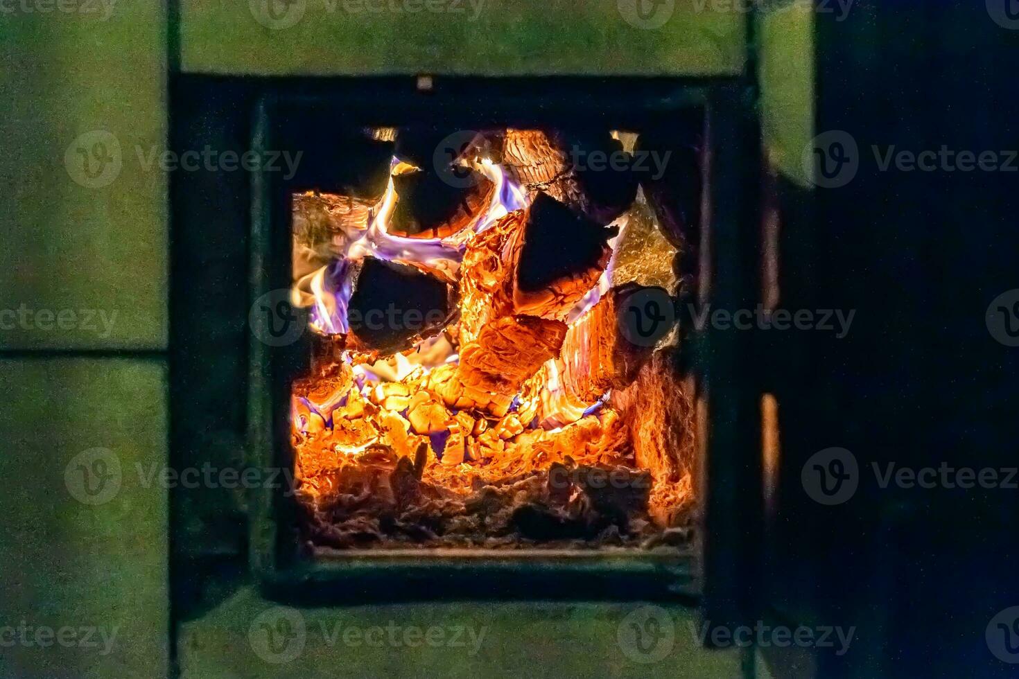 hermosa chimenea antigua con fuego de llama ligera para calentar la habitación del edificio foto