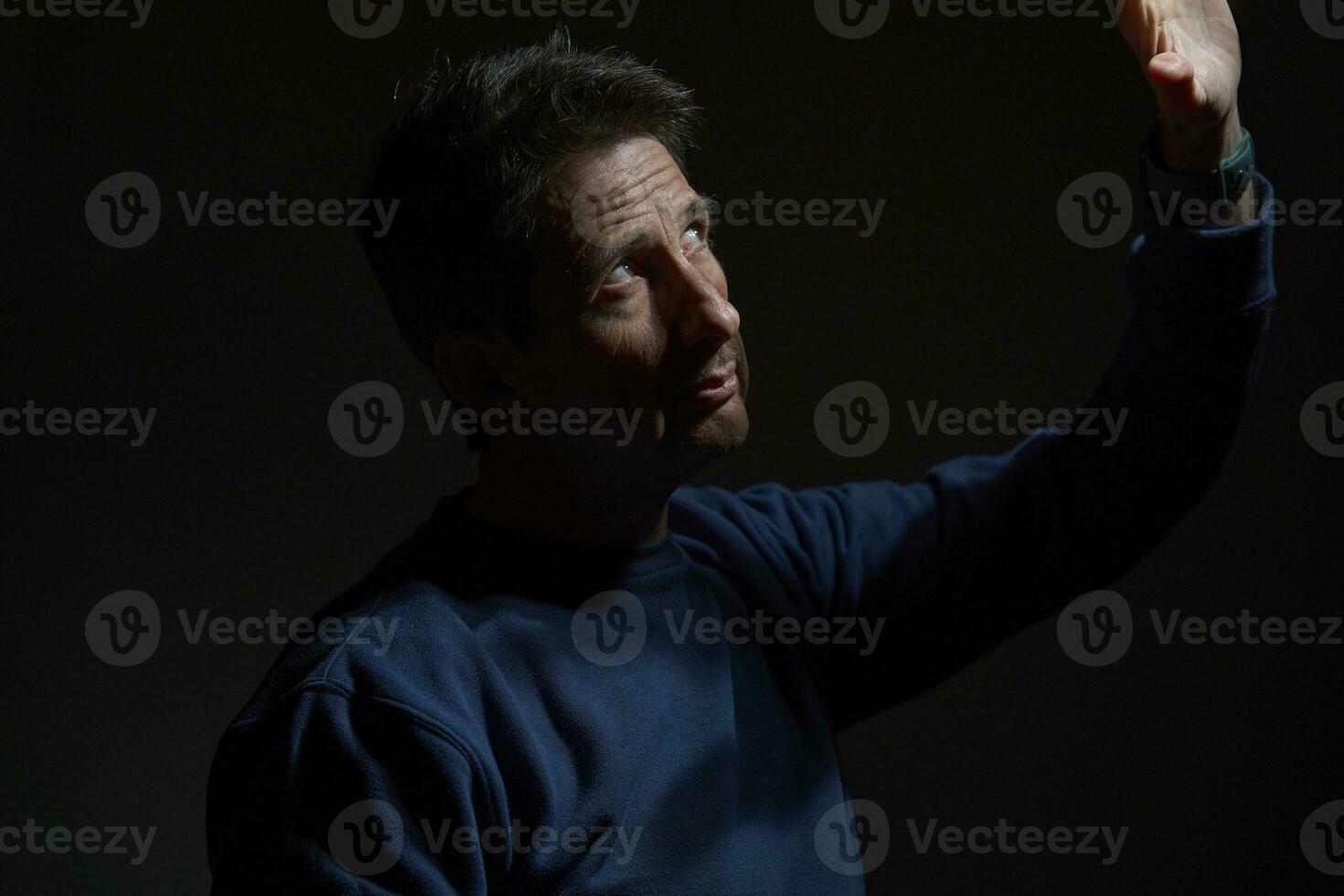 A 50-Year-Old White Man Leaning Against the Wall with an Expression of Interest photo