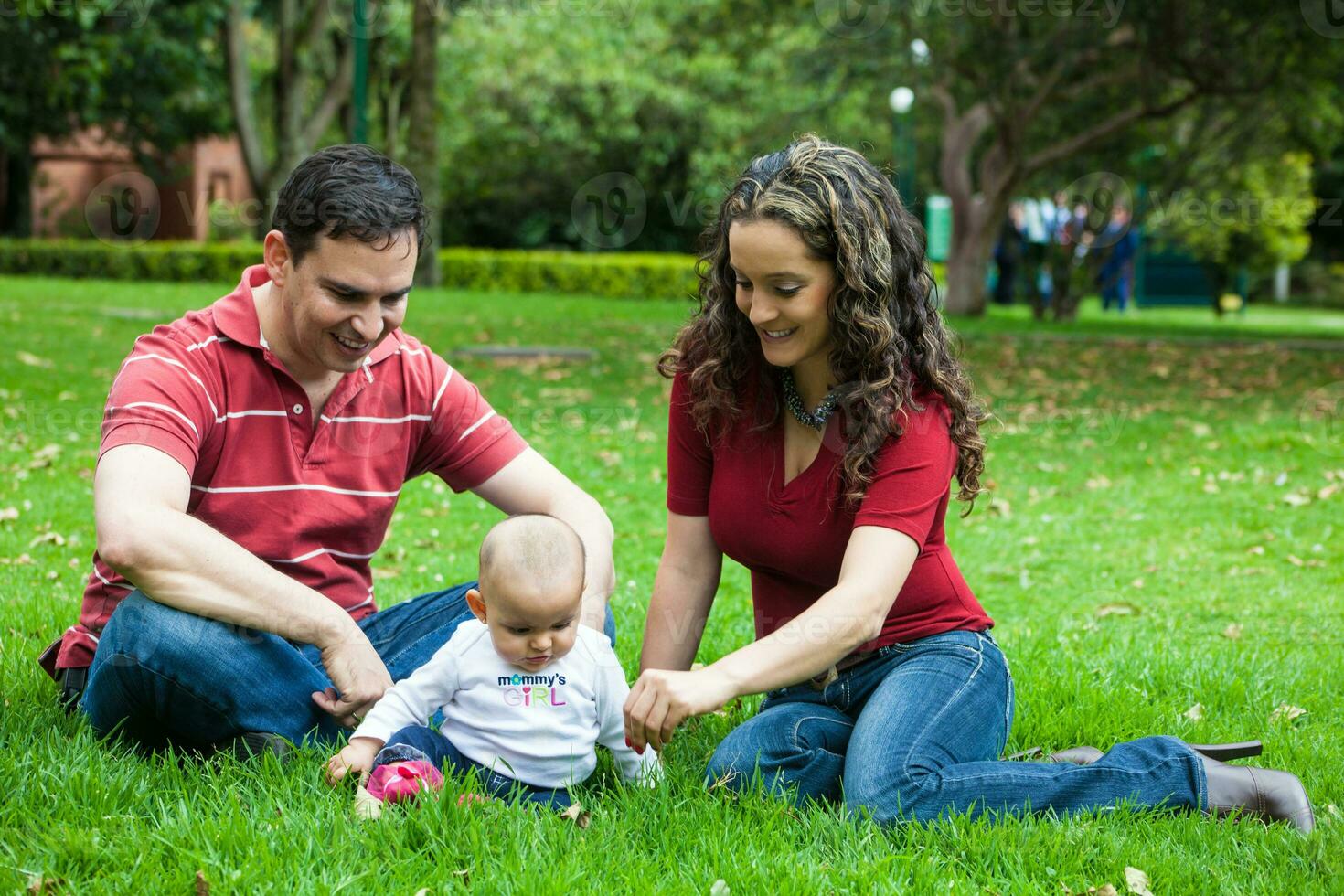 Young parents having fun outdoors with their six months old baby girl. Happiness concept. Family concept photo