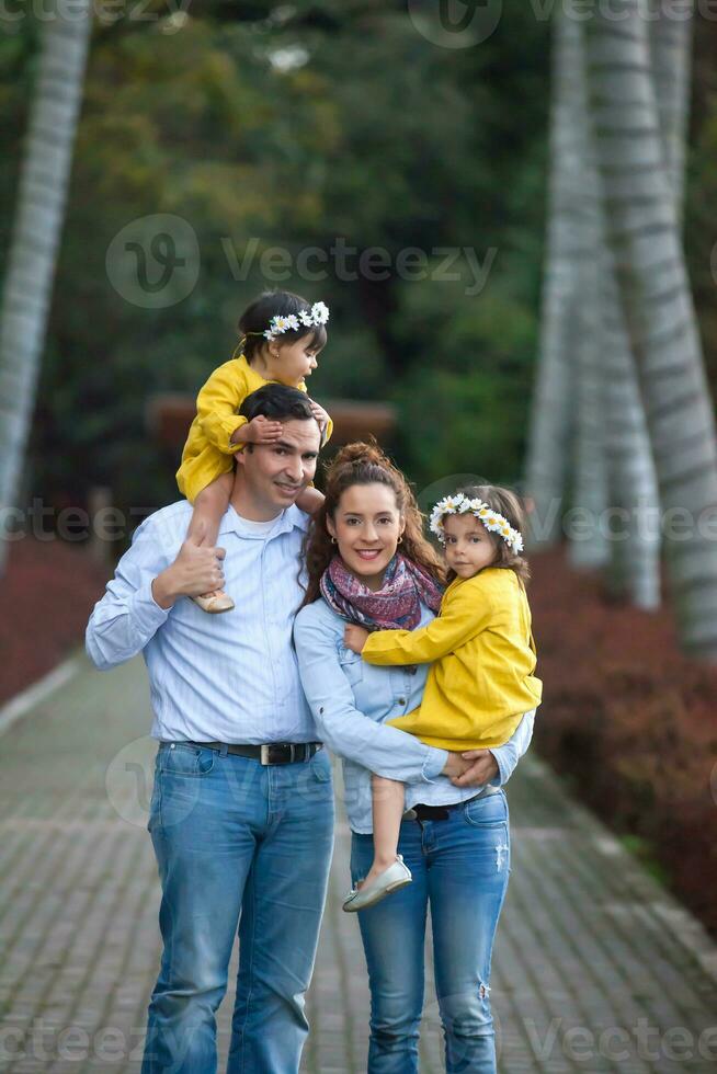 Family of four having fun outdoors in a beautiful sunny day at the park. Happiness concept. Family concept. photo