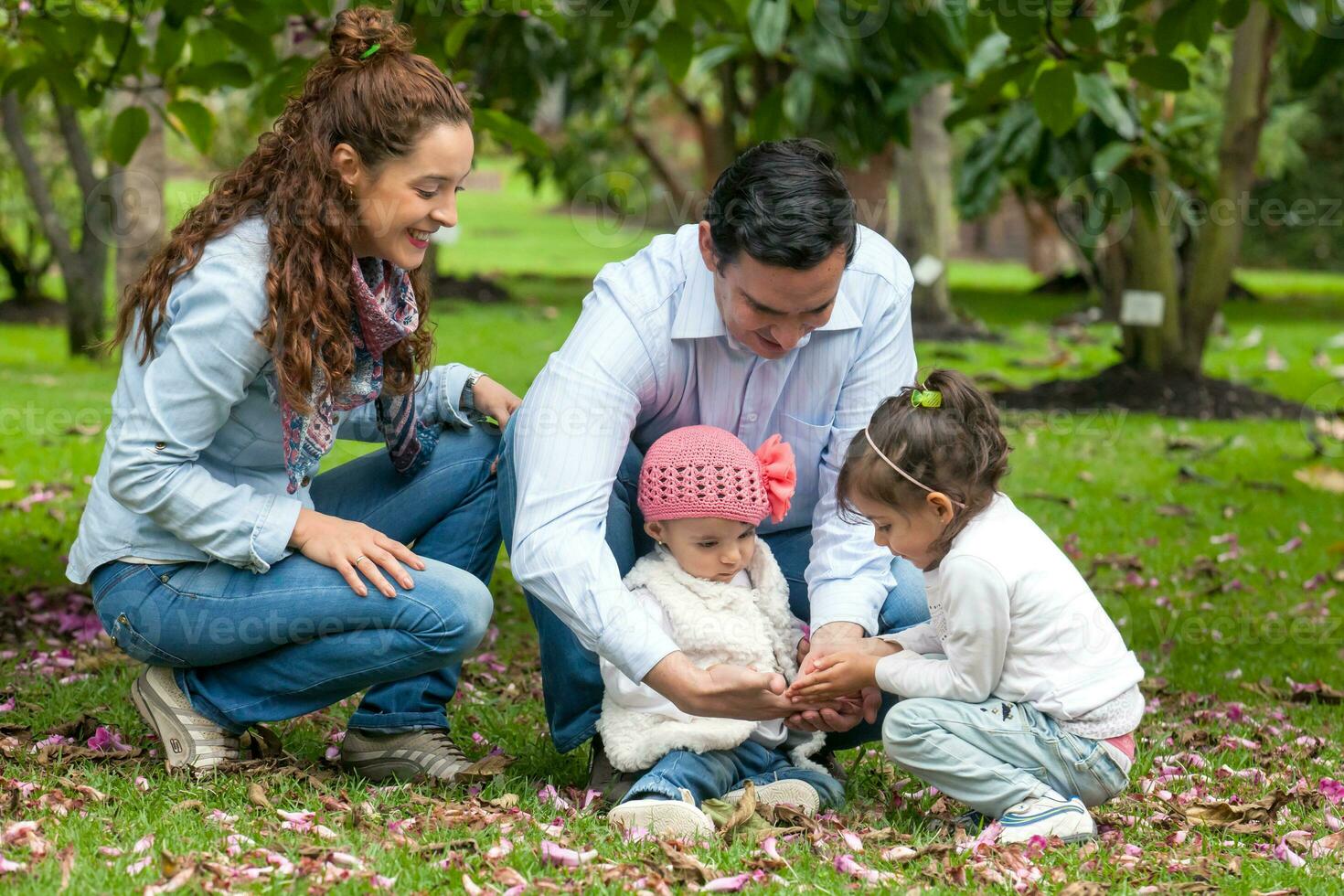 Family of four having fun outdoors in a beautiful sunny day at the park. Happiness concept. Family concept. photo