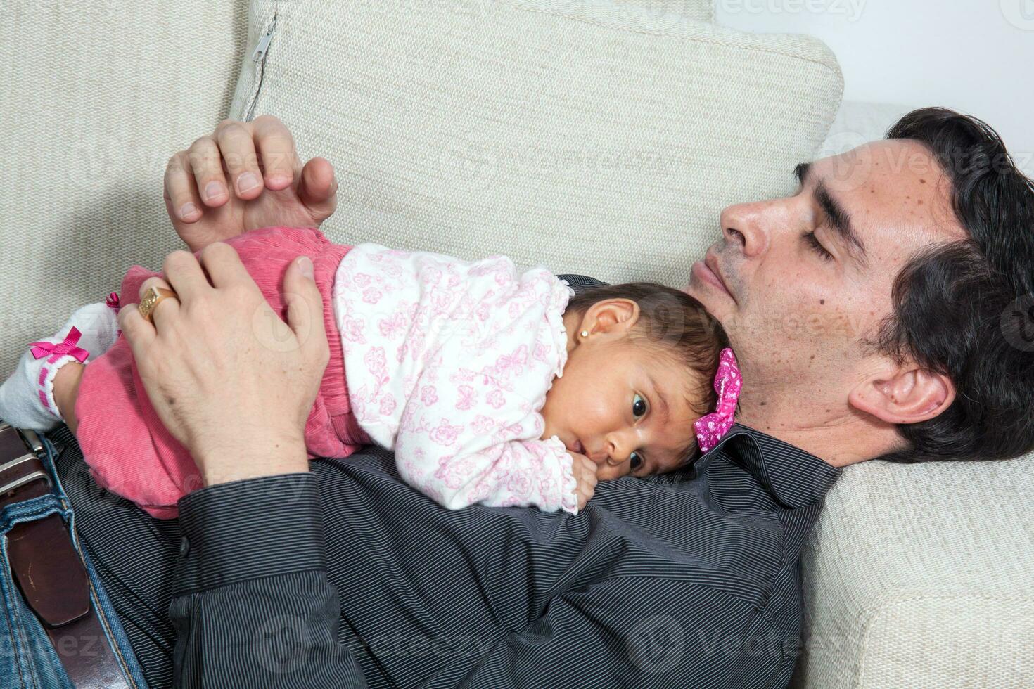 Portrait of young father at home with his one month baby girl. Fatherhood concept. Family love concept. photo