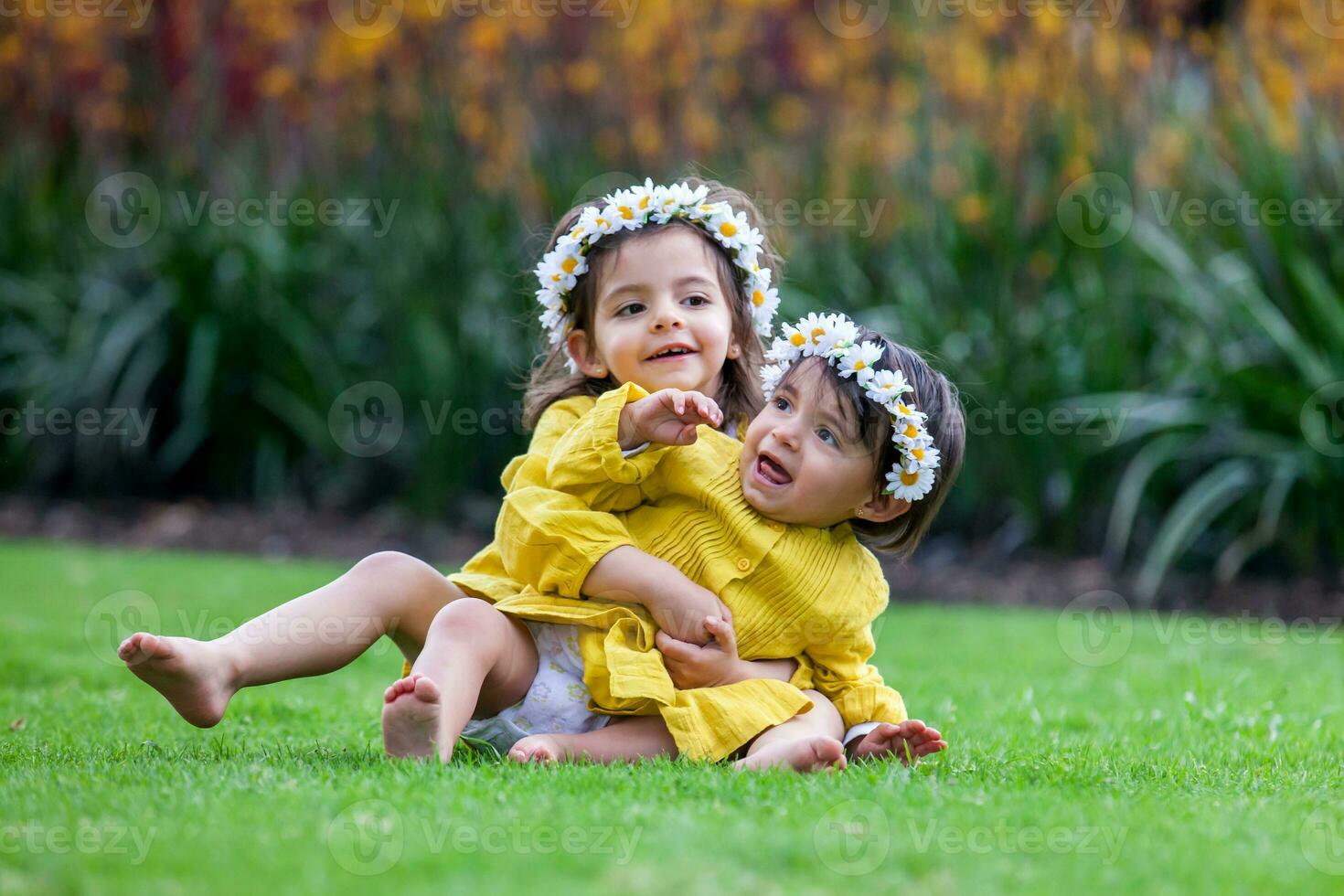 Beautiful small sisters dressed in yellow playing and having fun outdoors. Happiness concept. Family concept photo