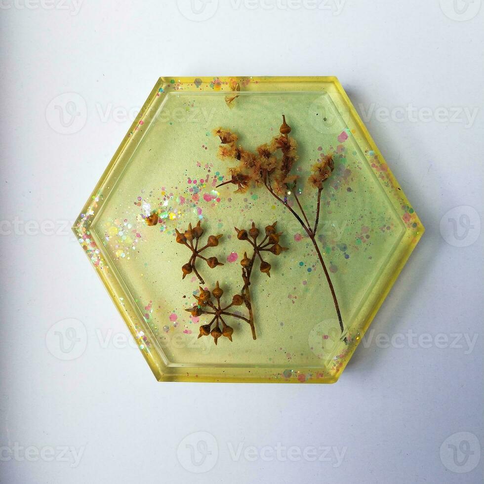 Handmade resin coaster with floral pattern on white background. Selective focus. photo
