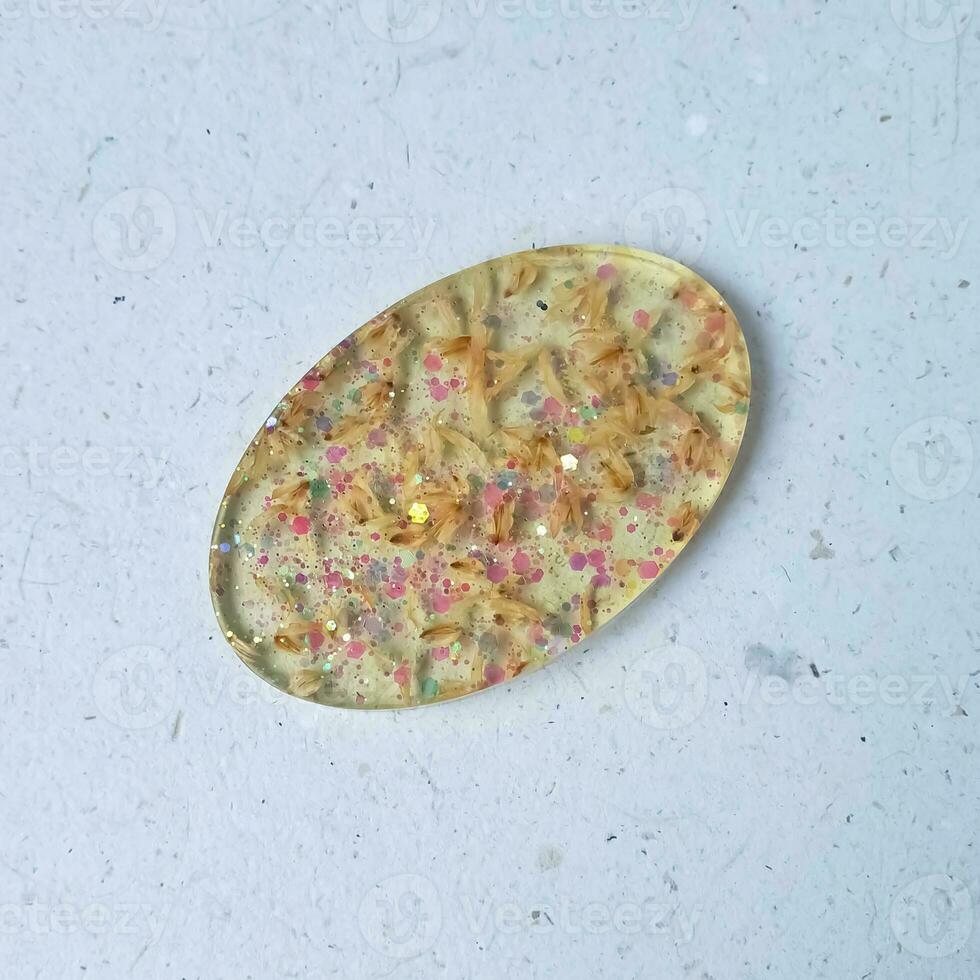 Handmade resin coaster with floral pattern on white background. Selective focus. photo