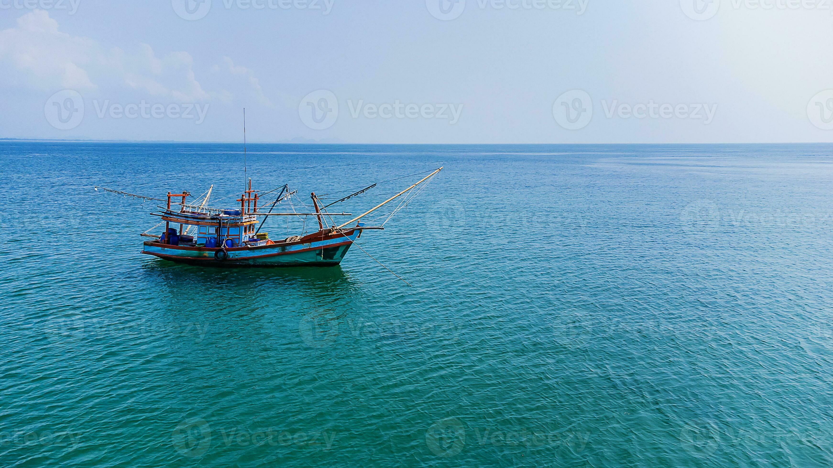 A small fishing boat floating in the sea 27484585 Stock Photo at Vecteezy