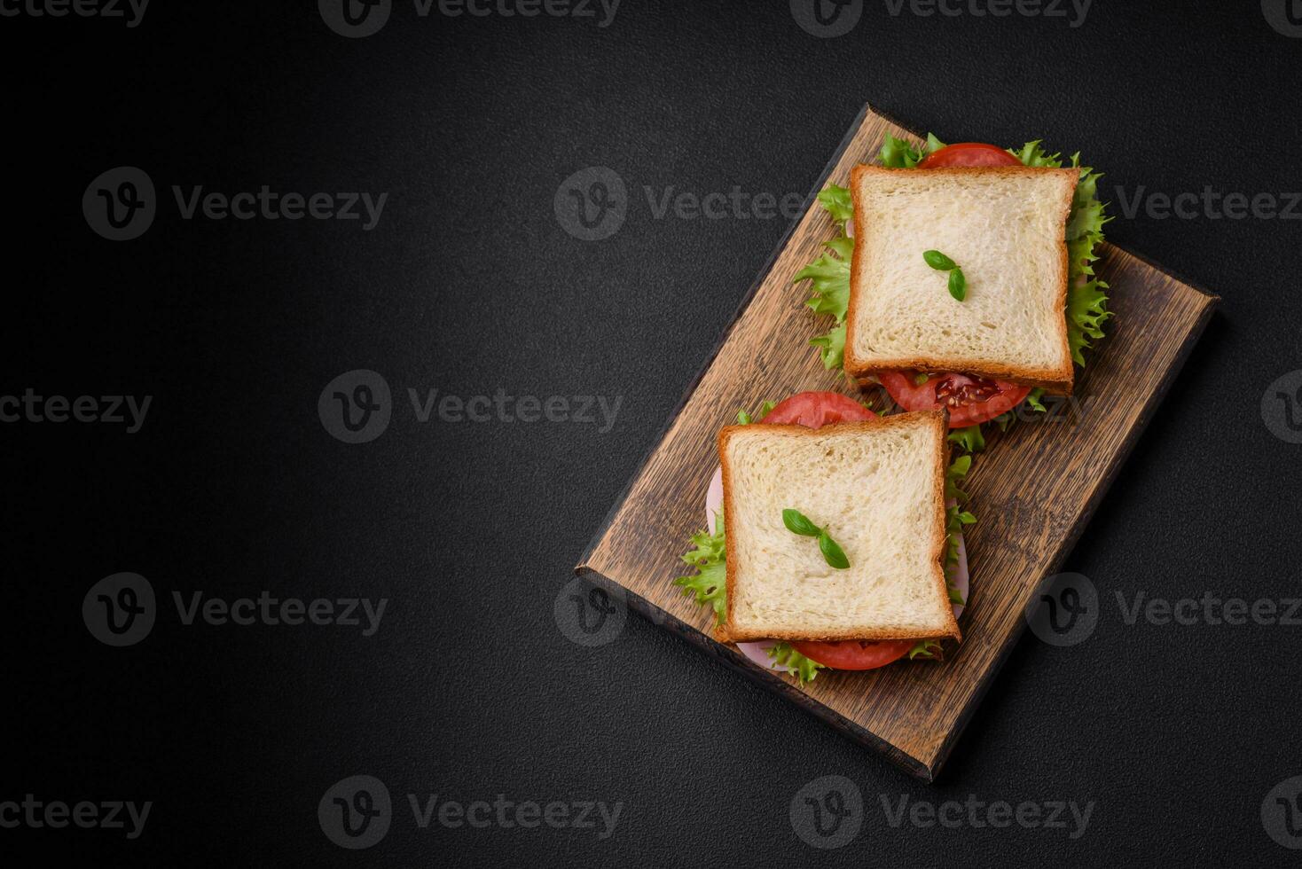 Delicious sandwich with toast, ham, tomatoes, cheese and lettuce photo