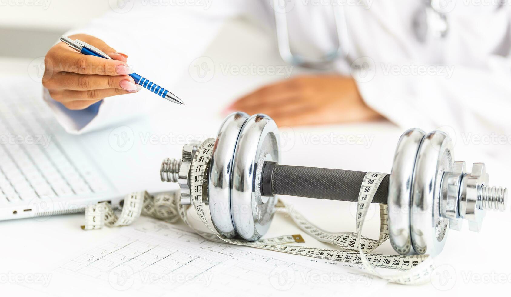 A doctor woman in surgeries prescribes sport movement and weight loss using dumbbells and a measuring tape. photo