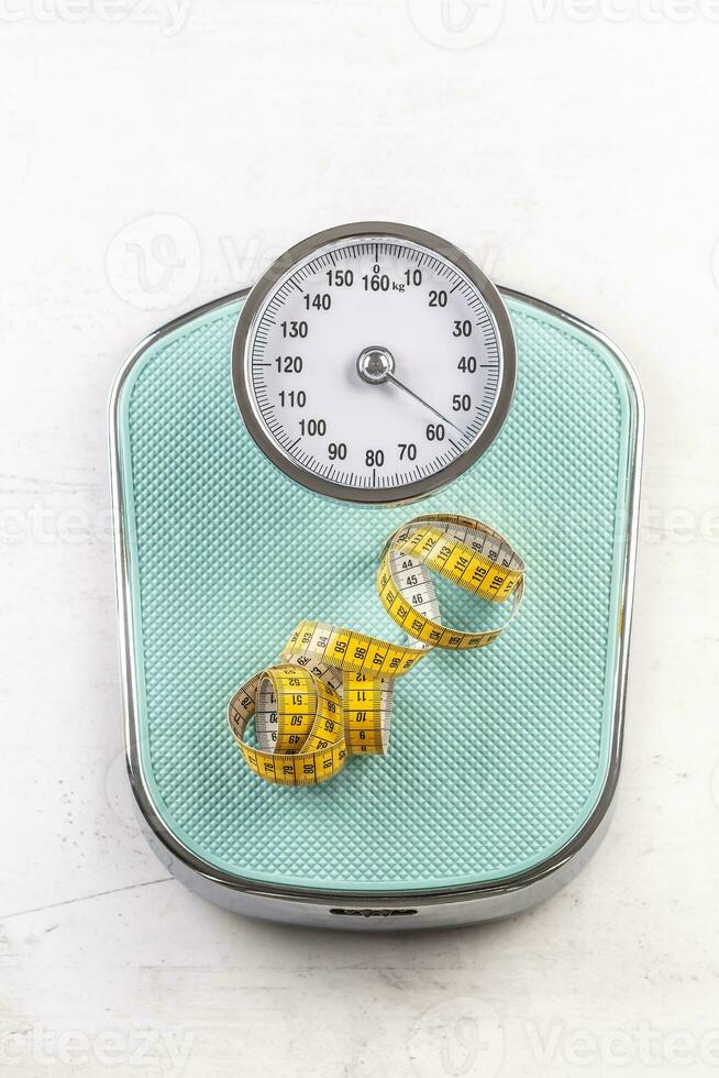 Weight scale with measure tape on floor - Top of view photo