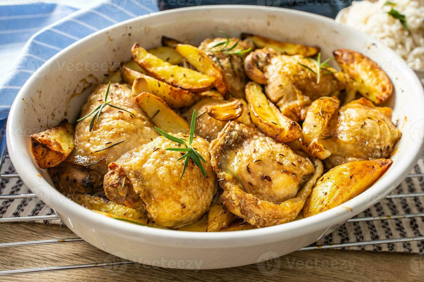 Chicken legs roasted with american potatoes in baking dish photo