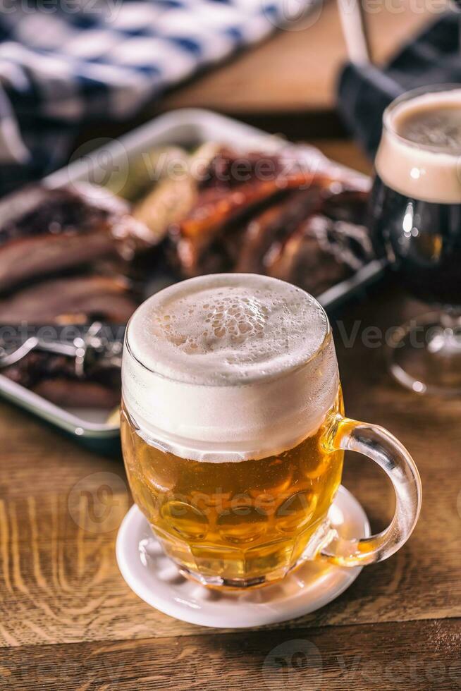 Glass of light beer in pub or restavurant on table with delicoius food photo