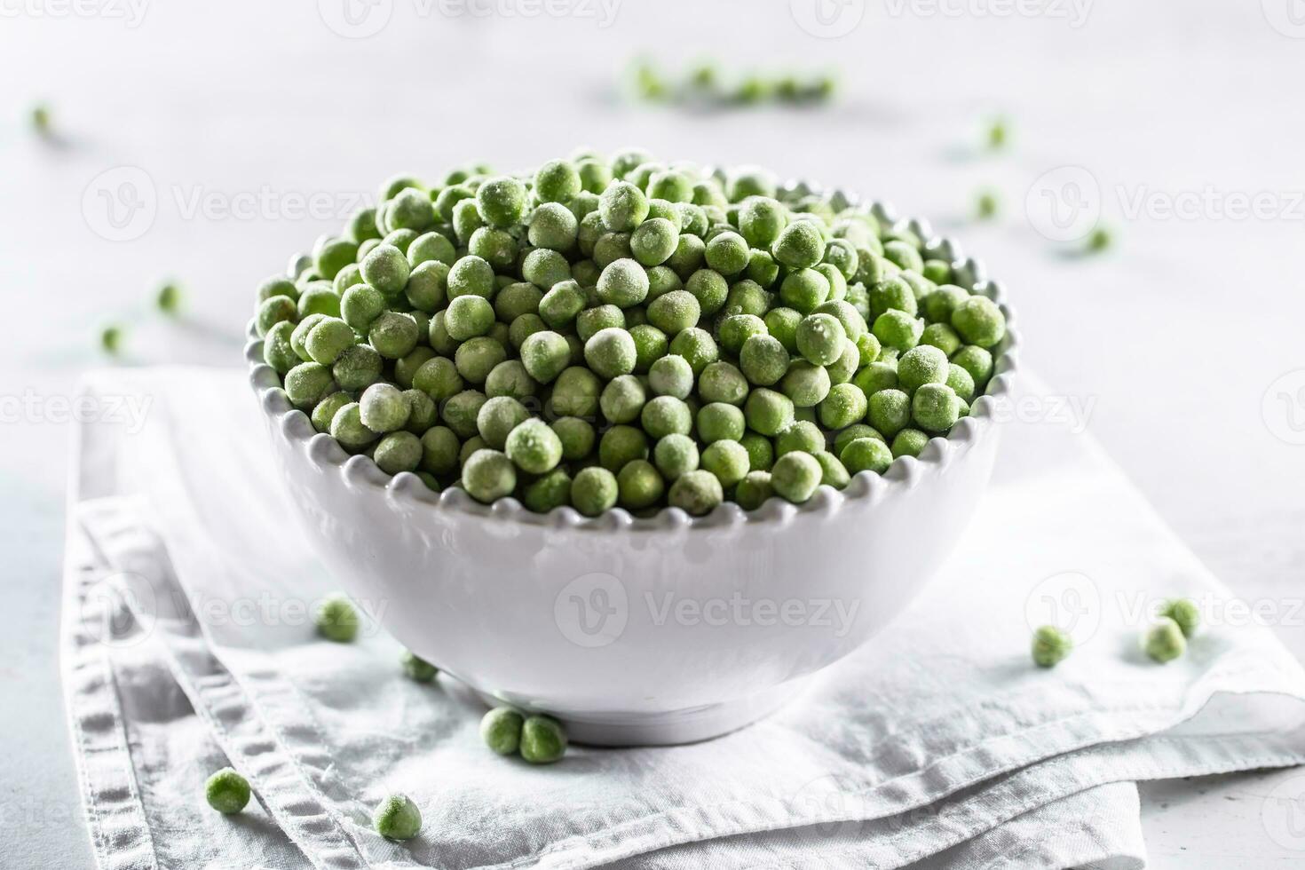 Frozen peas in a white porcelain bowl photo