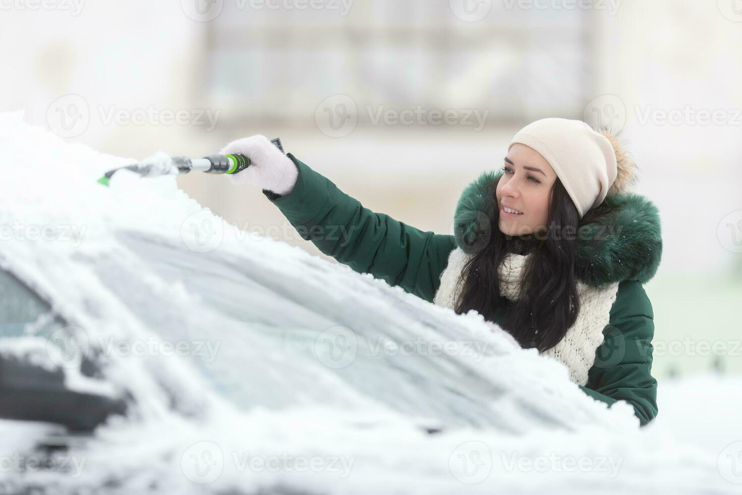 Clearing snow from the car is just one part for good visibility in winter that should be followed by scraping ice from windshields photo
