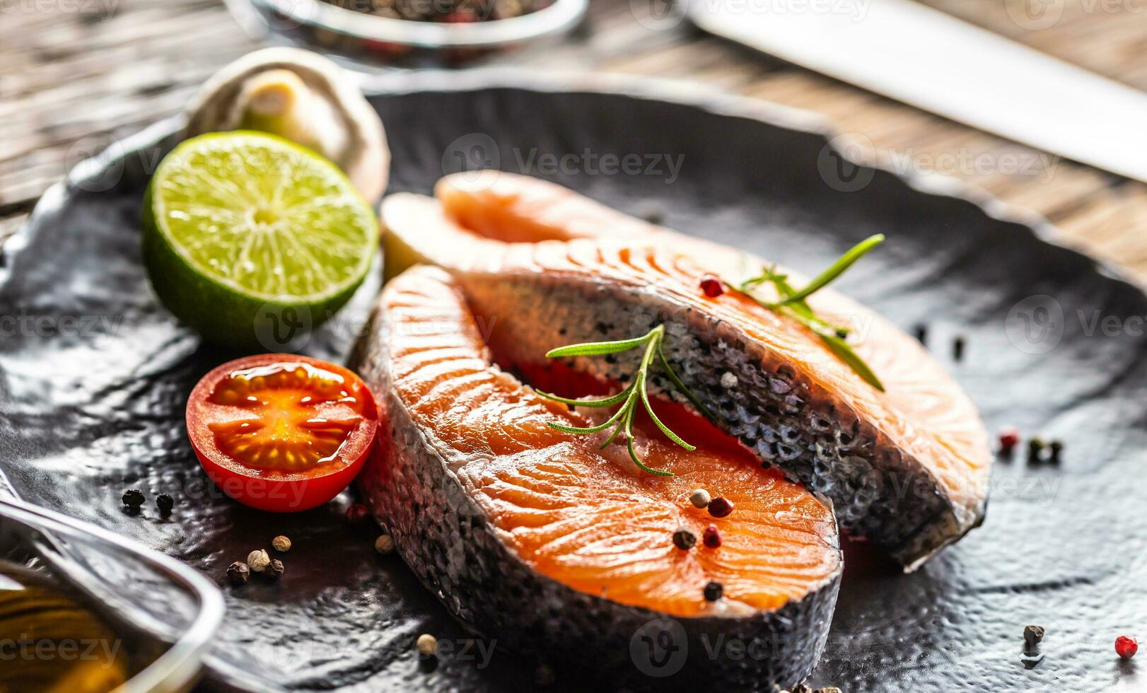 salmón crudo filetes Romero Tomates seta Lima aceituna petróleo y especias - de cerca foto