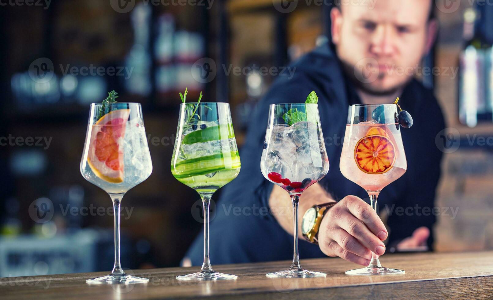 barman en pub o restaurante preparando un Ginebra tónico cóctel bebidas en vino lentes foto