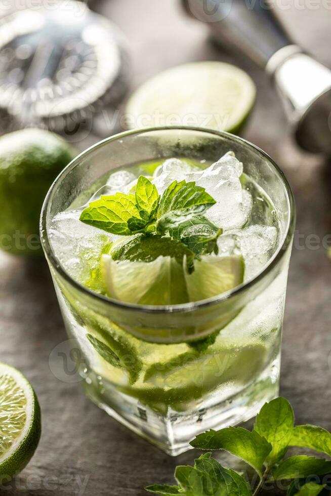 Mojito cocktail drink with white rum lime mint herbs and soda on the bar counter photo