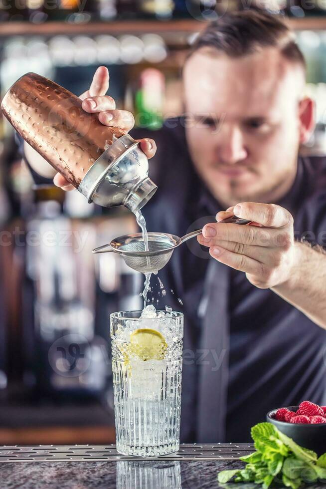 profesional barman haciendo alcohólico cóctel bebida con frutas azúcar y hierbas foto