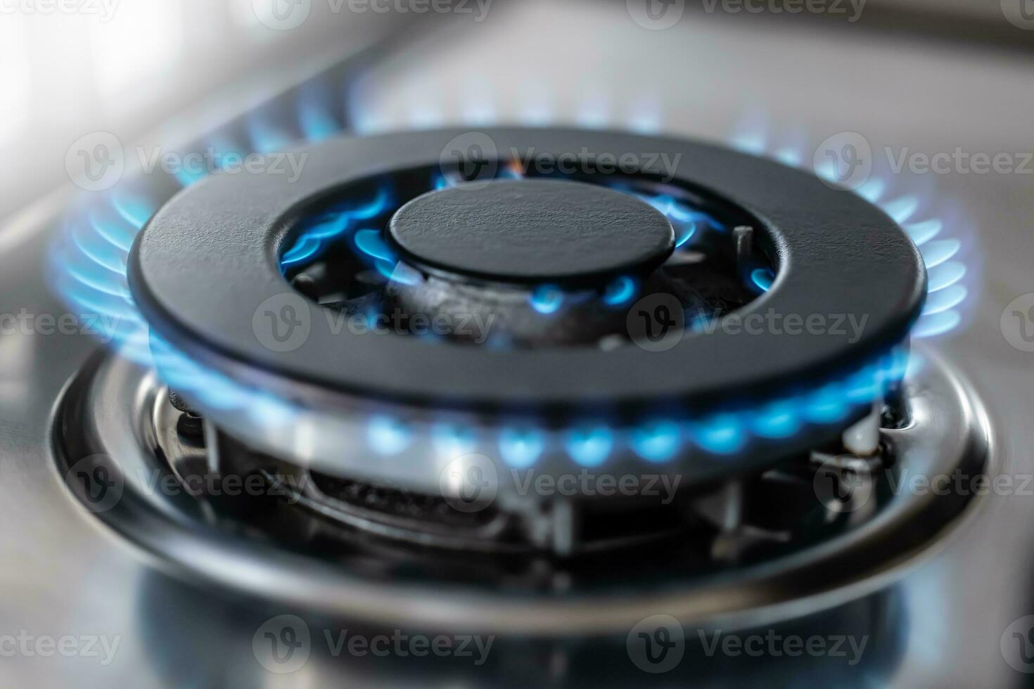 The gas burner burns with the blue flame of a propane butane stove in a home kitchen or hotel restaurant photo