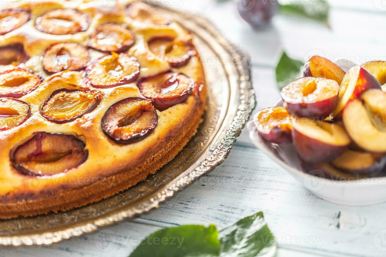 Homemade plum cake in vintage plate on wooden table. Plums pie with sugar powder photo