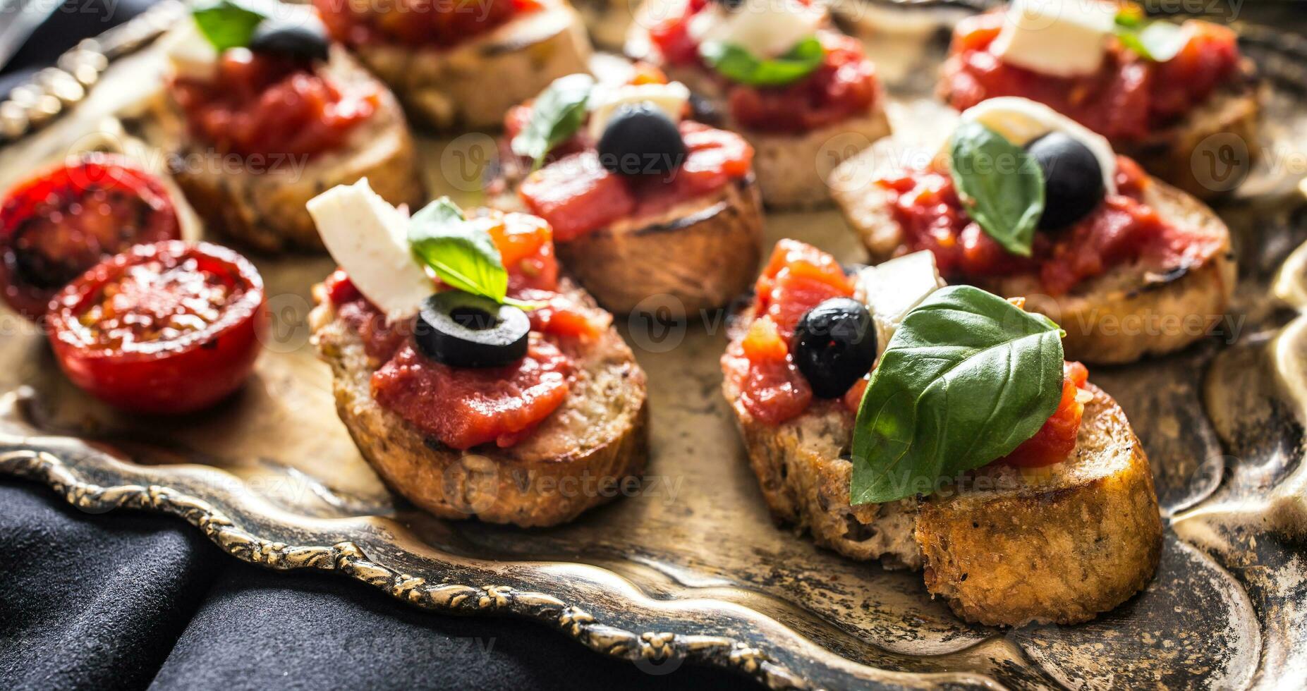 Bruschetta toast with mozzarella tomatoes olives photo