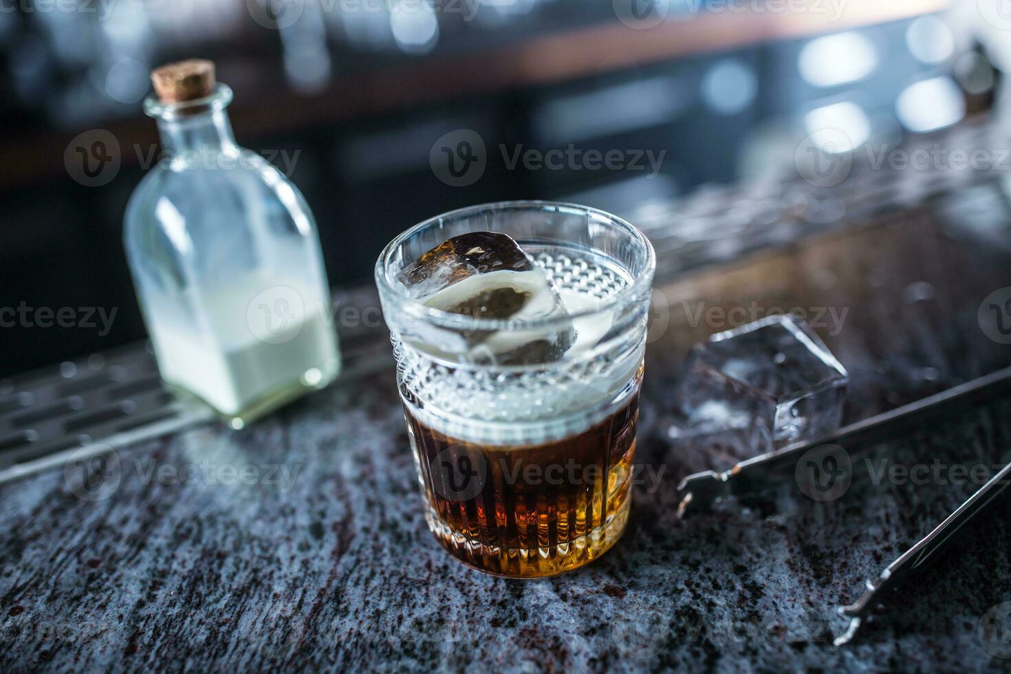 White russian cocktail drink at barcounter in night club or restaurant photo