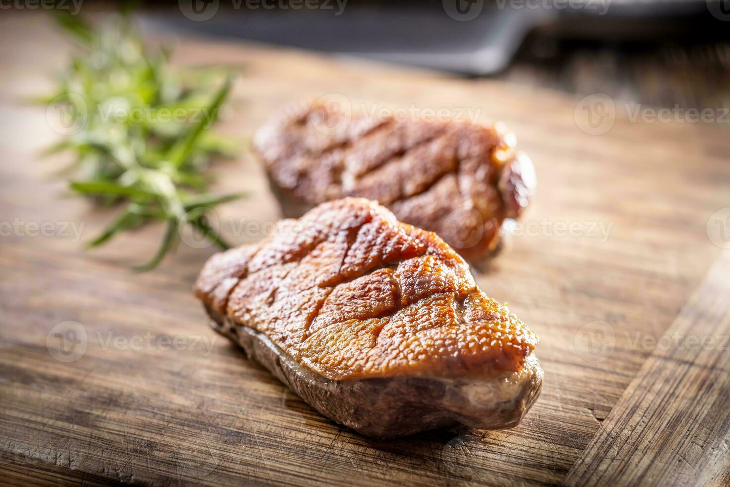 Roasted duck breast on a cutting board ready for slicing and serving photo