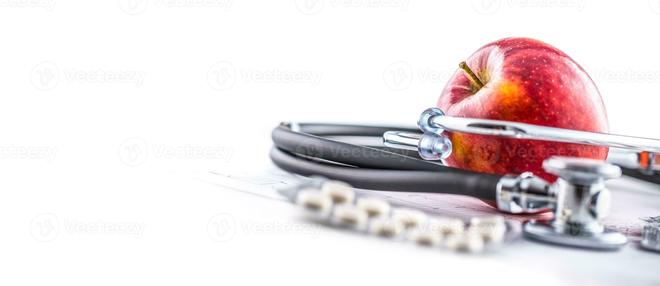 Stethoscope apple and pills on white background photo