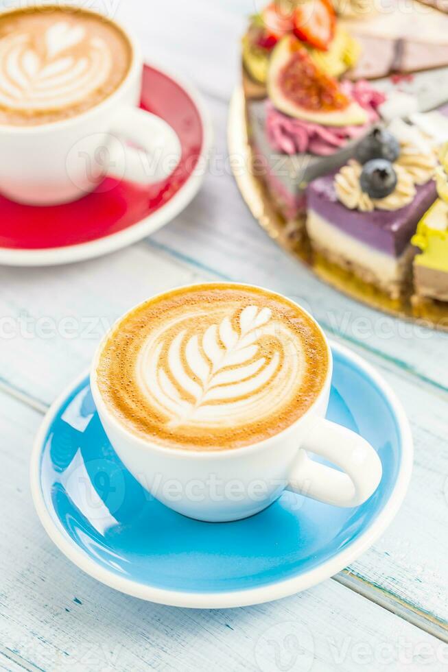 A cup of art coffee cappiciino and mini raw cakes photo