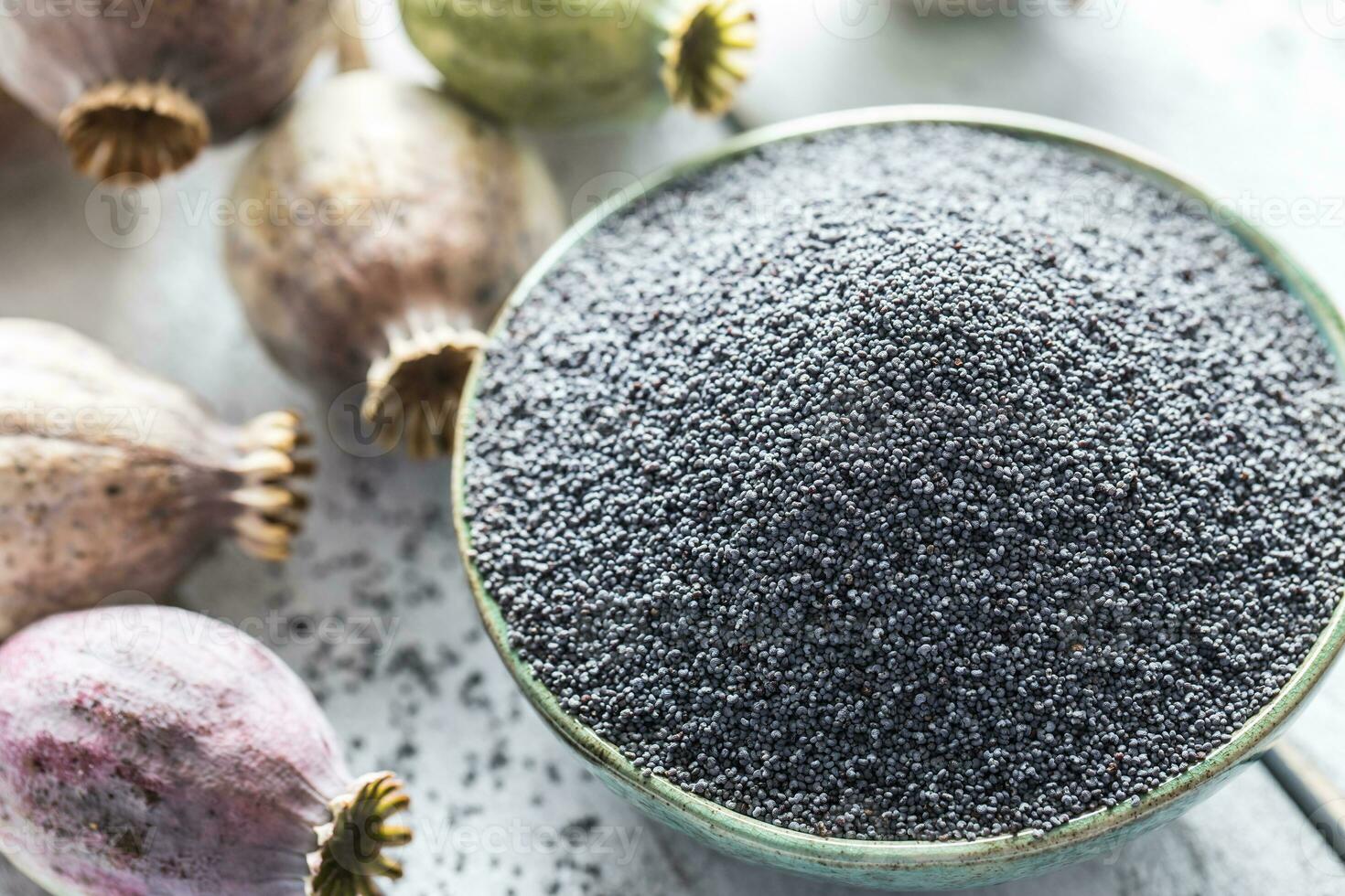 Poppy seed with their heads on wooden boards photo