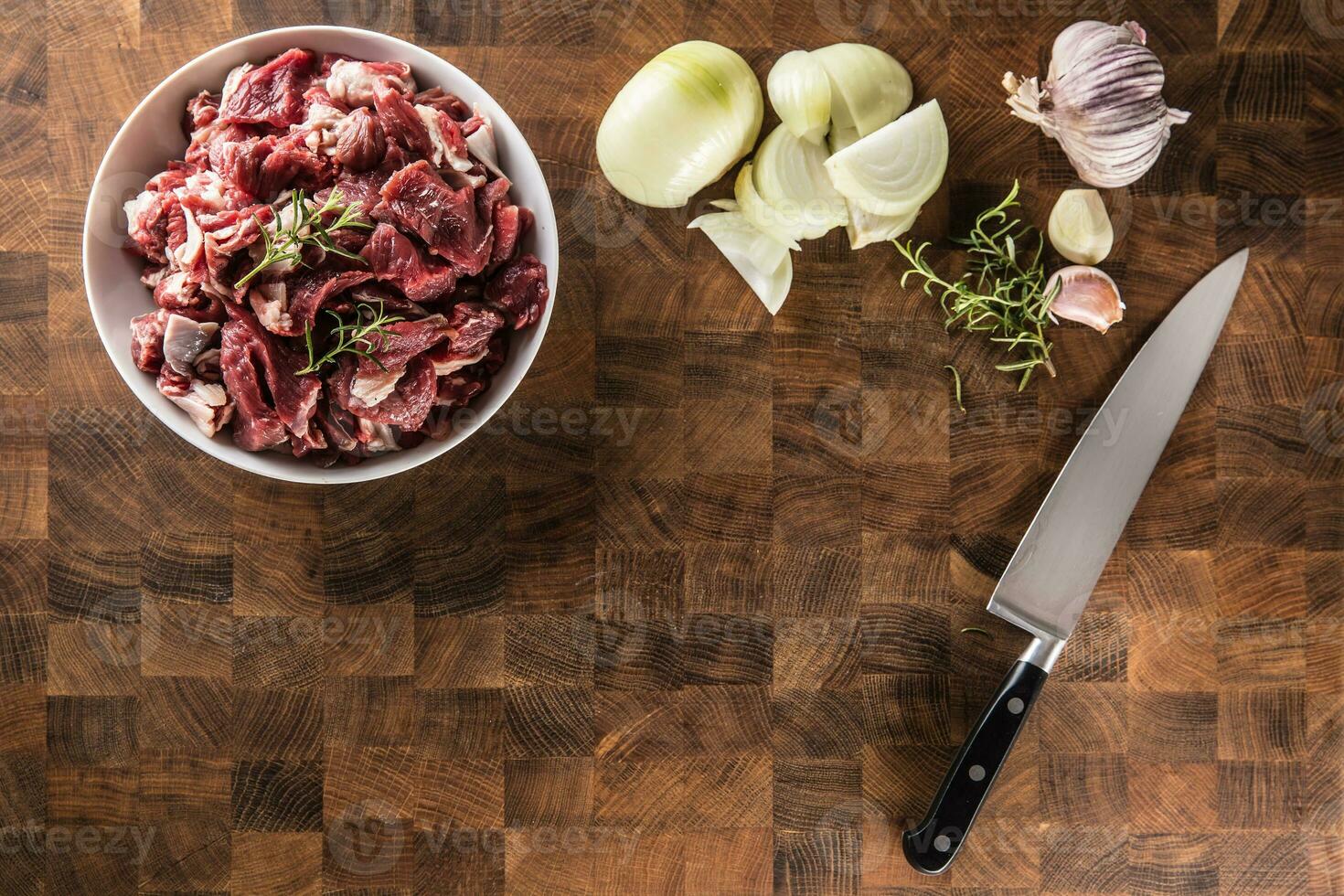 rebanado piezas de carne de vaca en plato con Romero cebolla y ajo foto