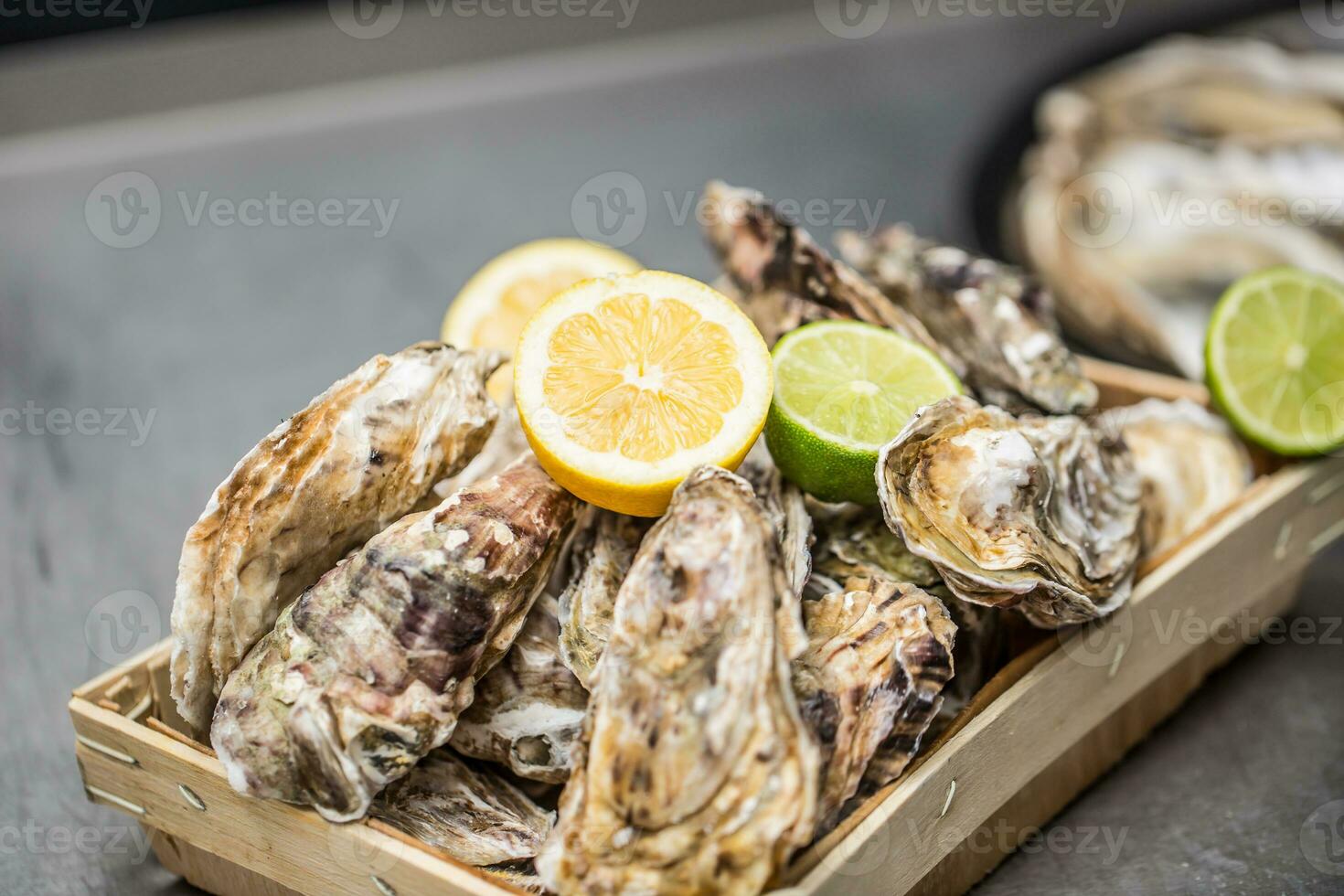 Several oysters in basket with lime and lemon photo