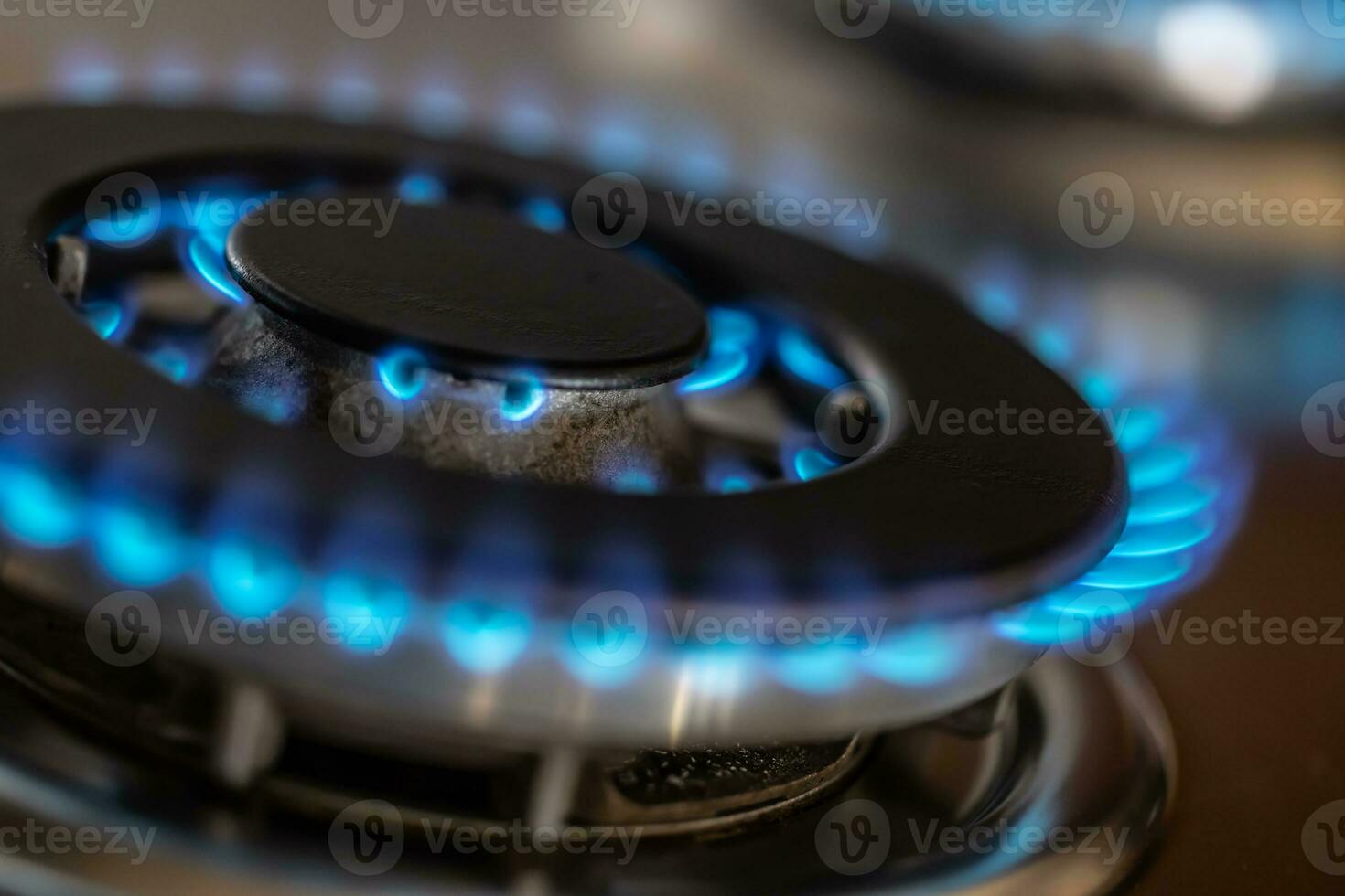 The gas burner burns with the blue flame of a propane butane stove in a home kitchen or hotel restaurant photo