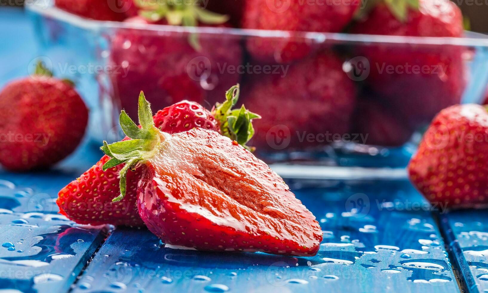 Fresco maduro fresas lavado con agua en azul mesa foto