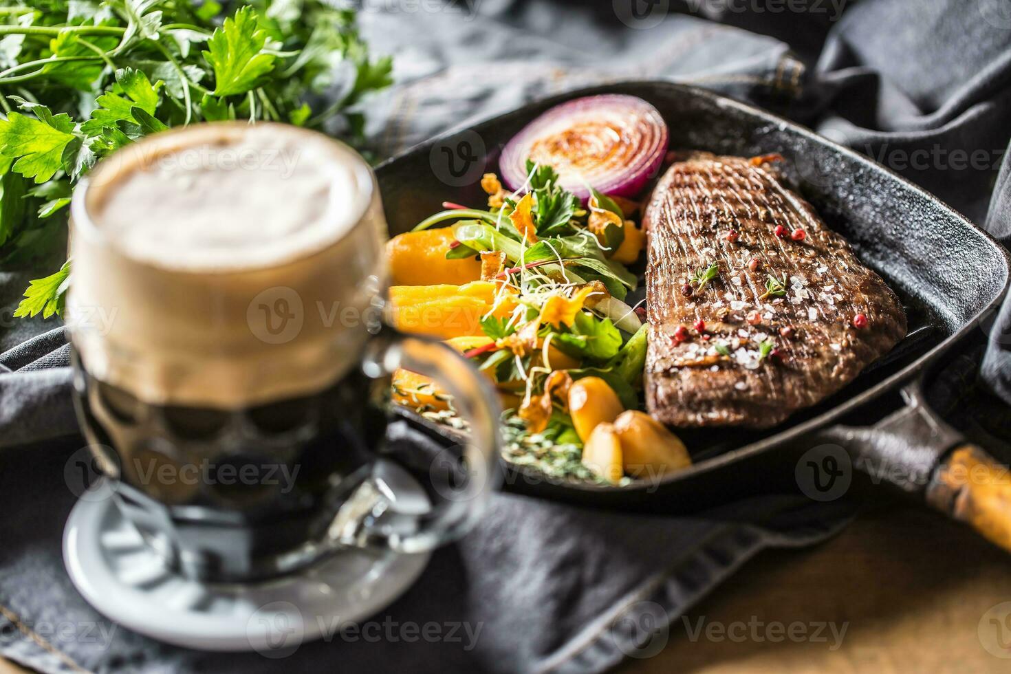 Glass of dark beer in pub or restavurant on table with delicoius food photo
