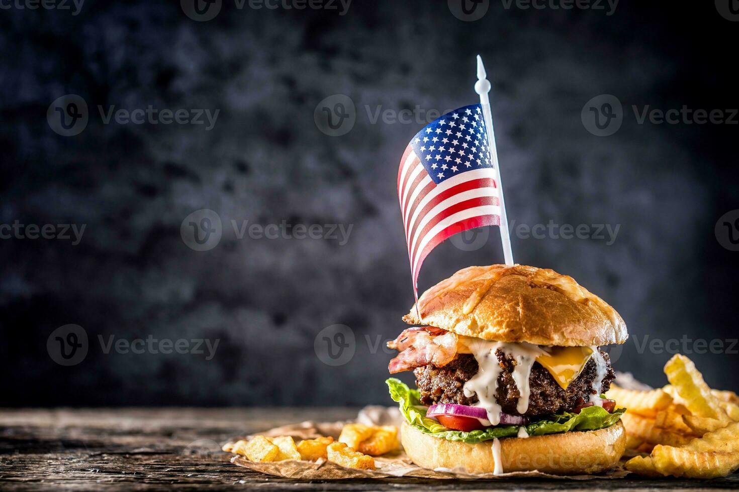 Close-up home made beef burger with american flag and fries on wooden table photo