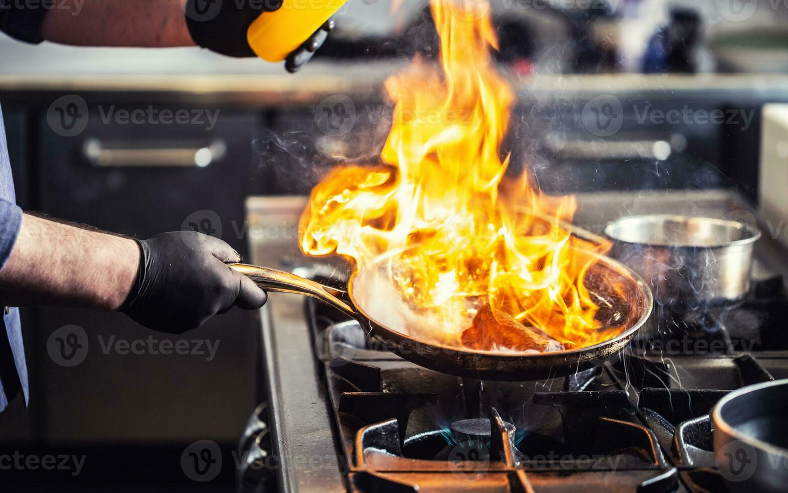 Detail of a flambe in a pan with flames reaching high photo