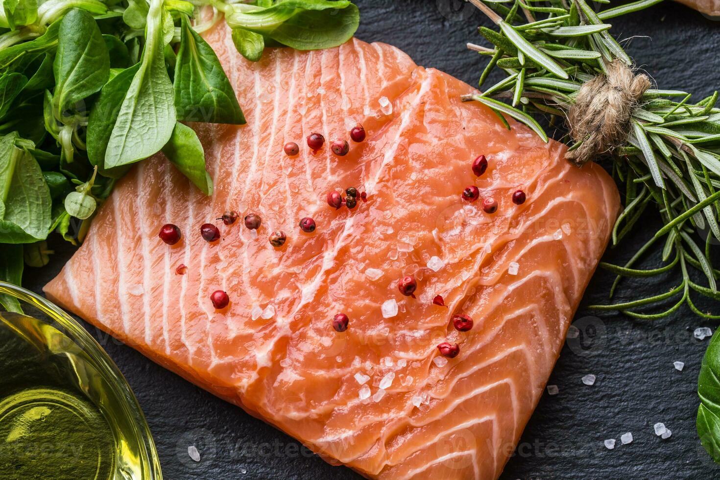 Raw salmon fillet with rosemary basil olive oil salt and pepper photo