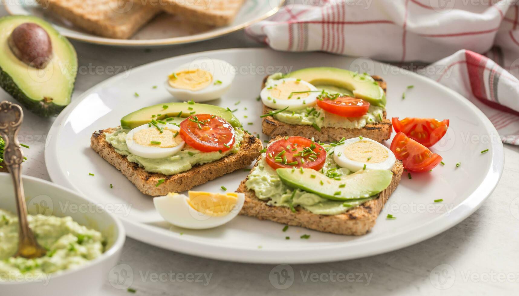 Healthy breakfast from toasts with avocado spread guacamole egg tomato and chives. photo