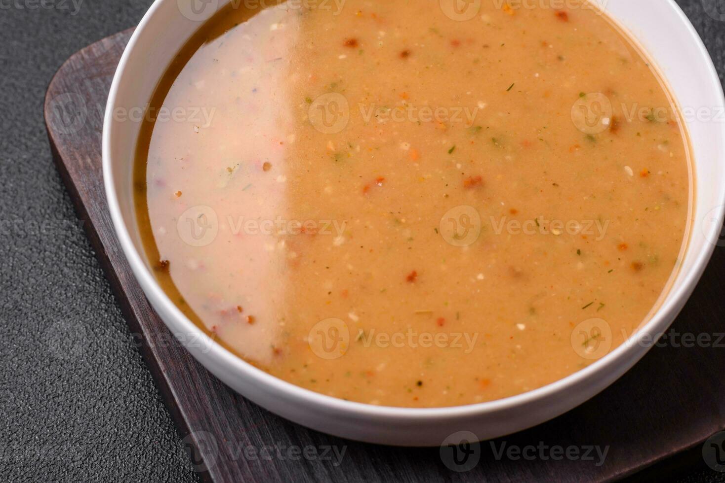 Delicious fresh vegetable soup with carrots, peppers, potatoes and onions photo