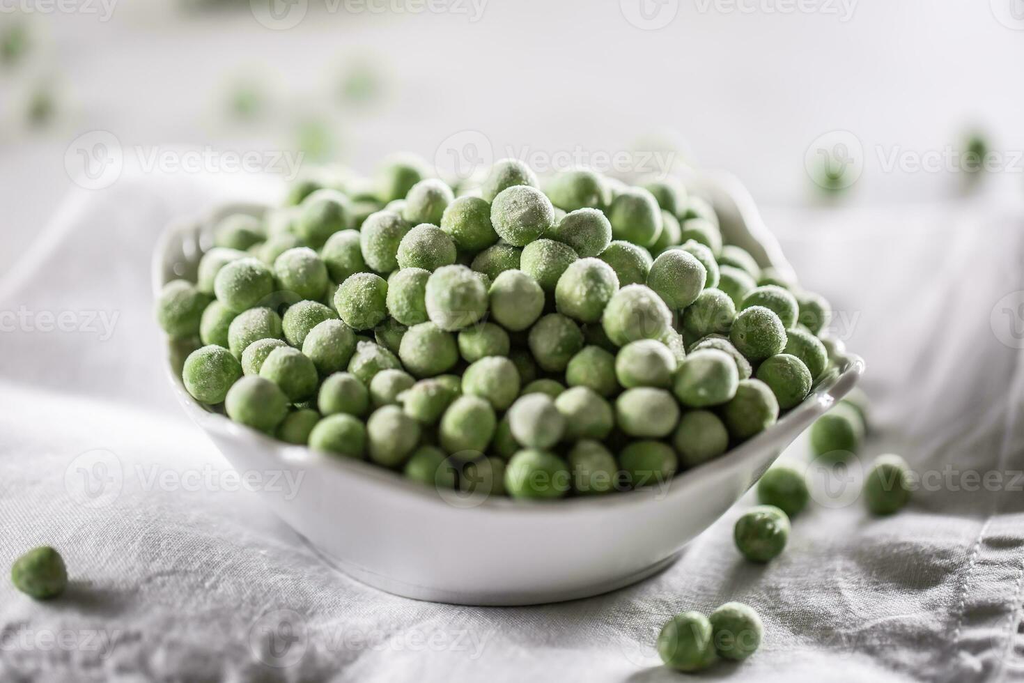 Frozen peas in a white porcelain bowl. photo