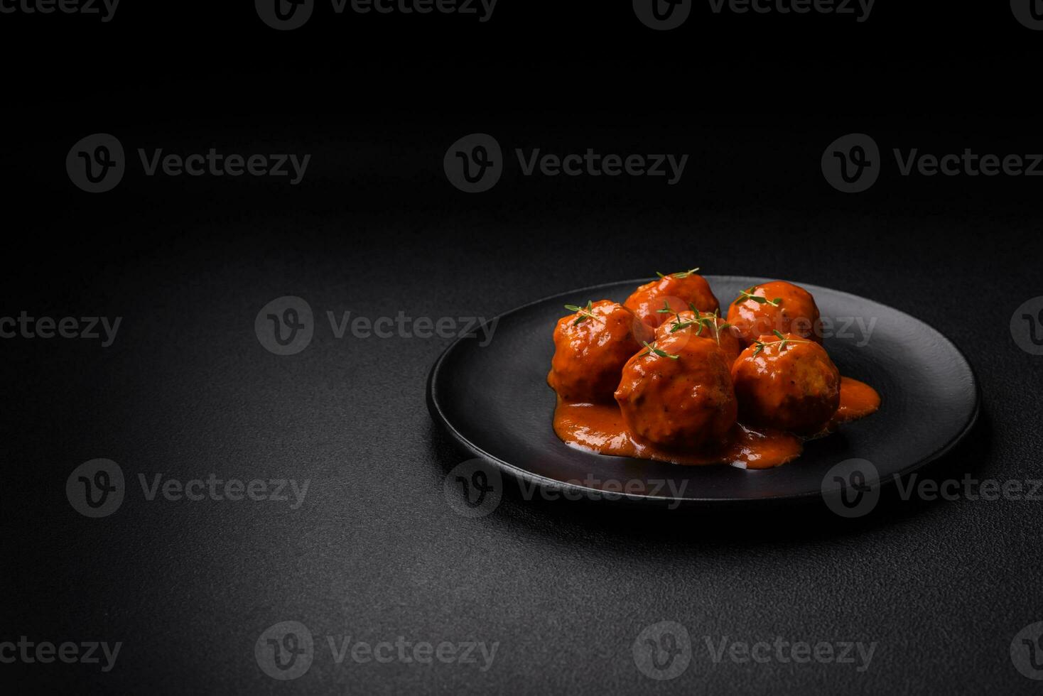 Delicious fresh meatballs in tomato sauce with salt, spices and herbs photo