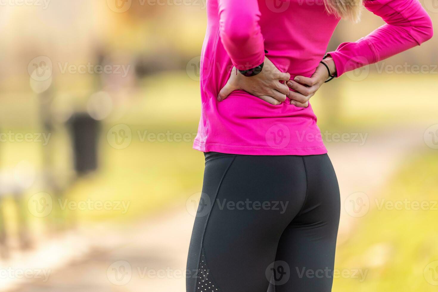 Young woman with an athletic figure and a lower back injury. Back pain during sports photo