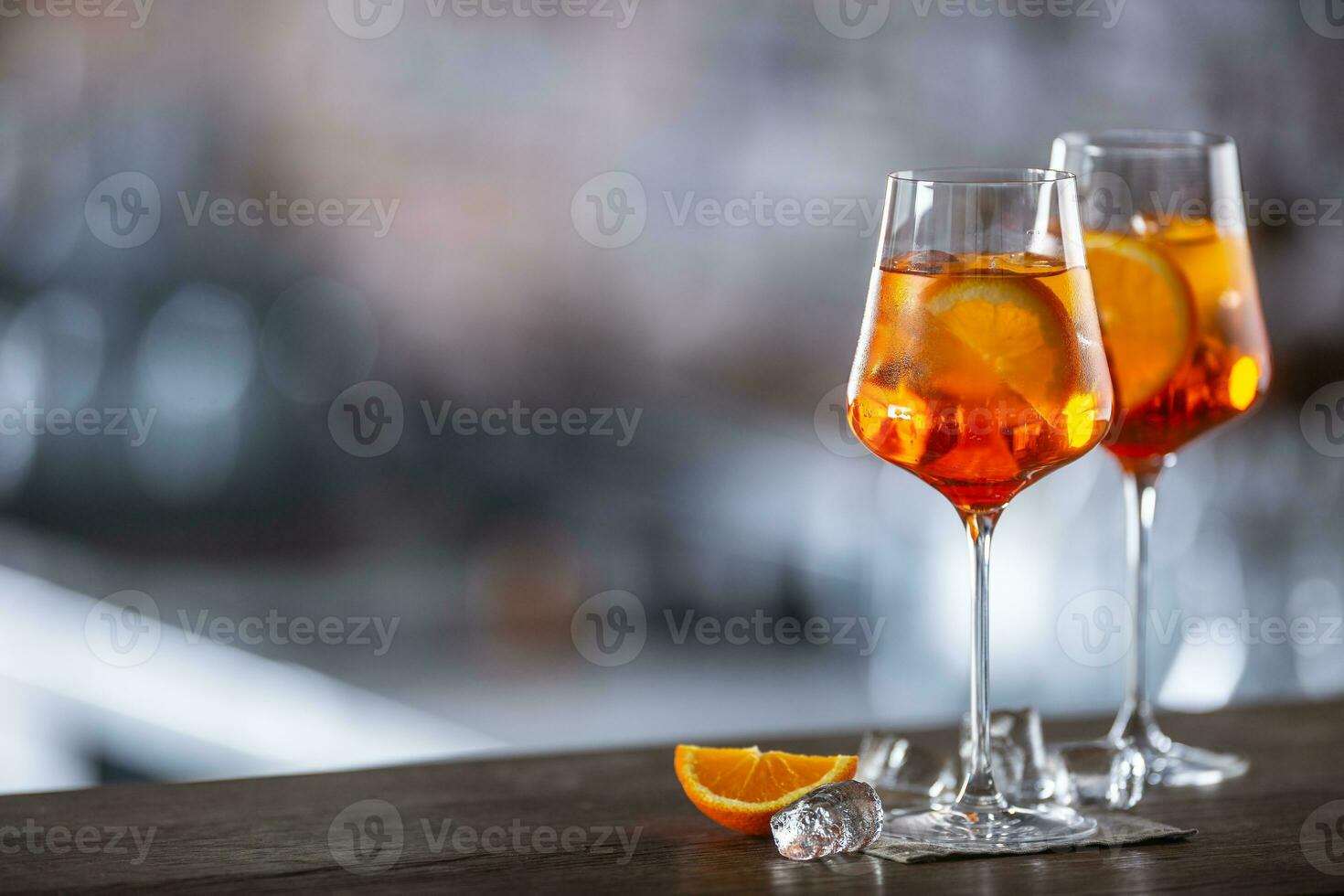 Typical summer sekt drink aperol spritz served in wine glass with aperol, prosecco, soda and a slice of orange photo