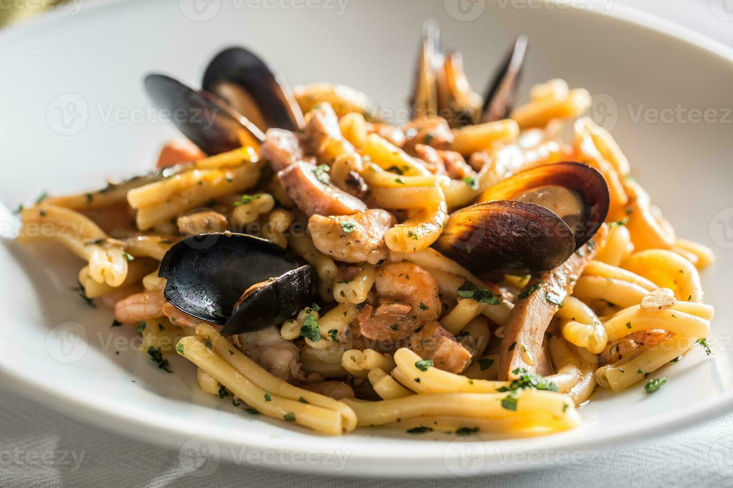 Italian pasta with mussels and prawn in white plate photo