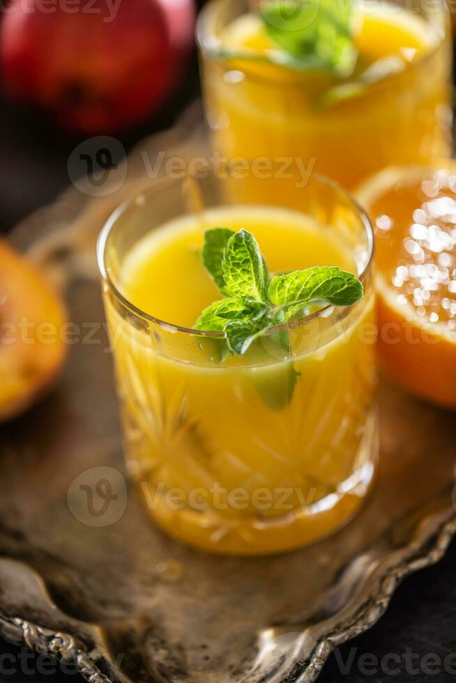 Two glasses with orange or multivitamin juice with mit herbs photo